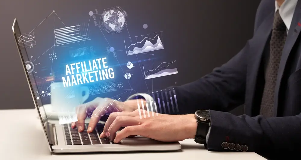 A person in a suit types on a laptop with the text "Affiliate Marketing" and various charts and graphs overlaid on the image, illustrating how Affiliate marketers can boost their profit through strategic analytics.