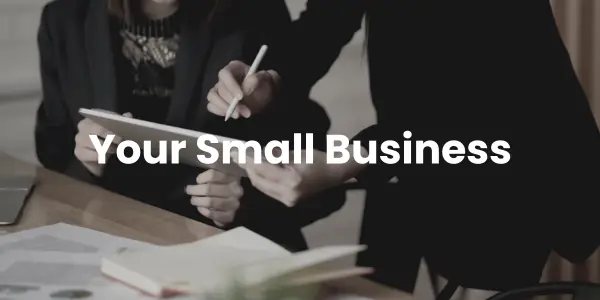 Two people in business attire are reviewing a document at a table cluttered with papers and a notebook. The text "Your Small Business Guide" is overlaid, providing a simple direction for aspiring entrepreneurs.